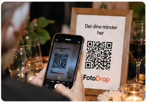 Gæst scanner FotoDrop QR-kode ved et festbord